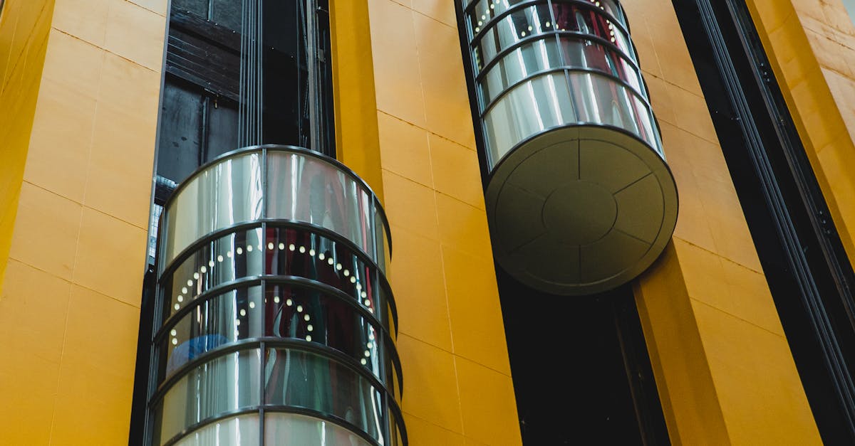 From below inside of high geometric modern multistory complex with round shaped lifts